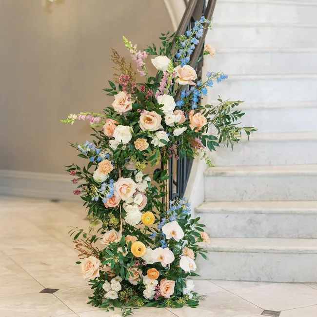 Composition florale pour escalier avec feuilles et rose de plusieurs couleurs